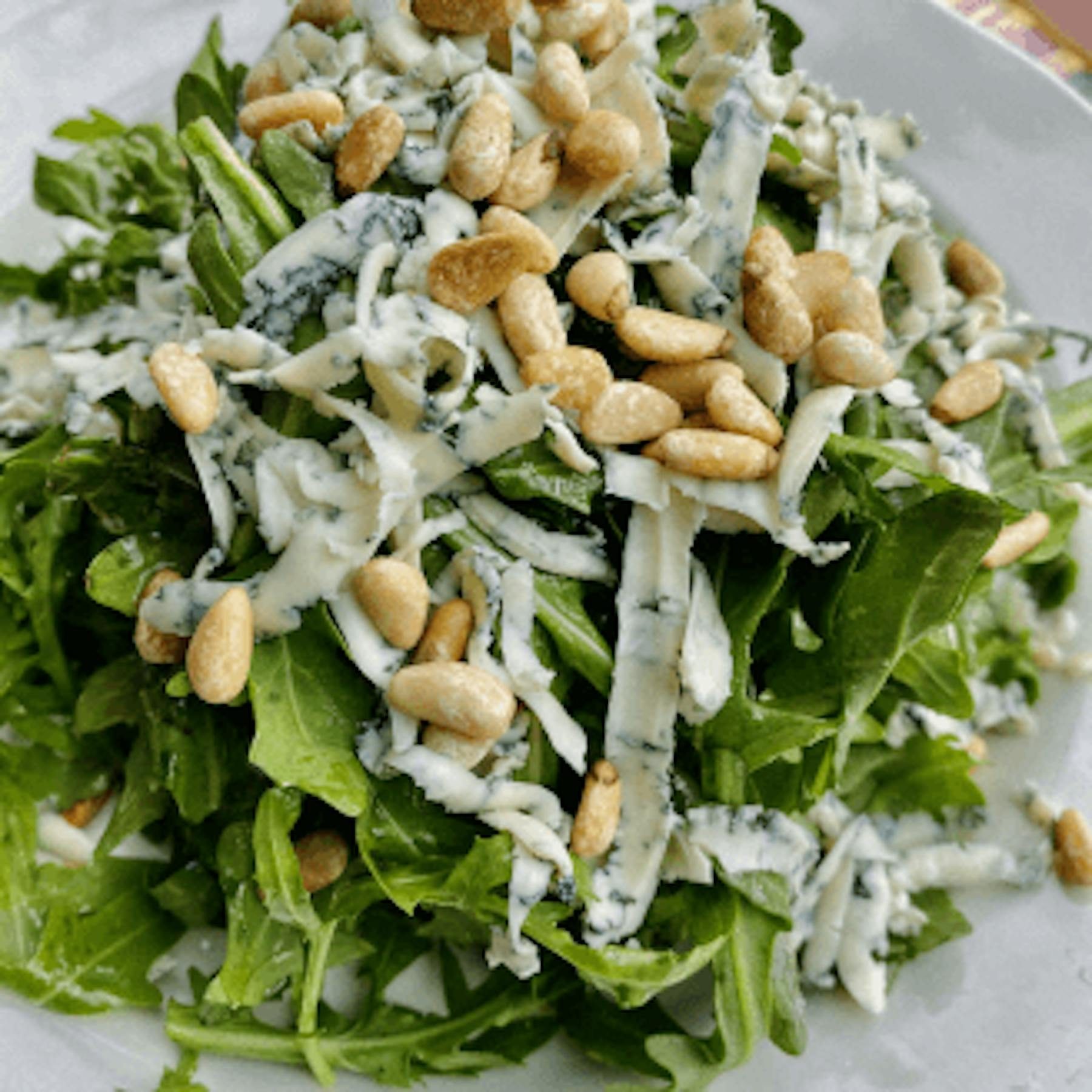 Insalata Di Rucola Con Pignoli Tostati E Scaglie Di Formaggio Erborinato Al Limone.